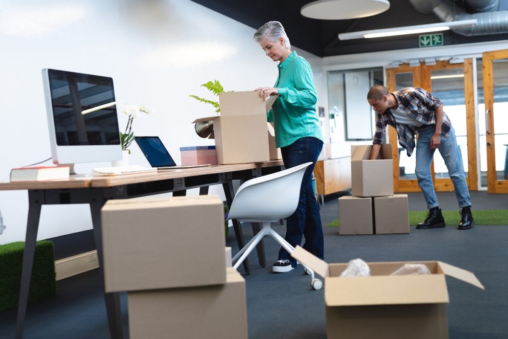 business revenue executives unpacking cardboard boxes in office