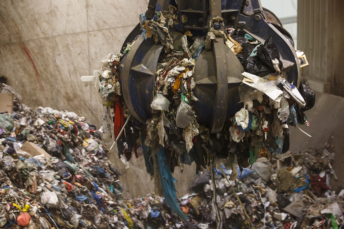waste management gripper holds garbage ready to deploy on roller convey istock656665854